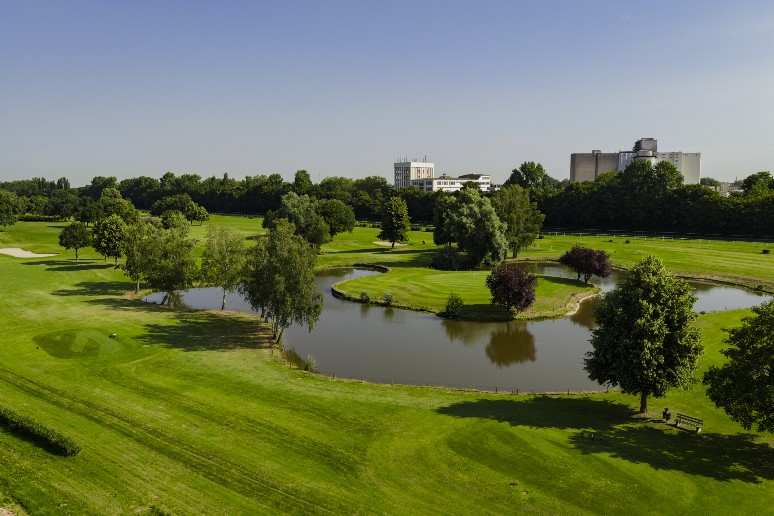 Gruppe junger Menschen begrüßt den Golftrainer zu Beginn des Platzreife Kurses auf dem Übungsgelände.